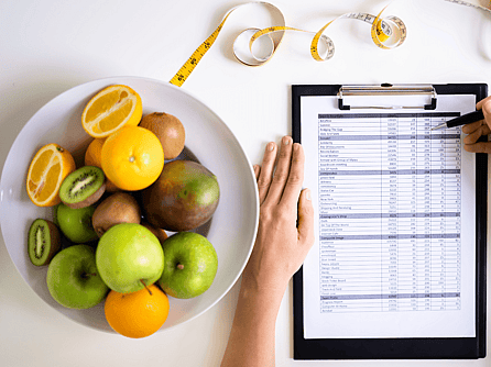 Dietitian presenting healthy eating tips with fruits and a presentation board