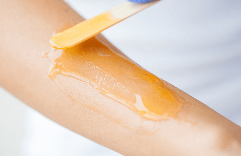 Image of hot wax being applied on arm 