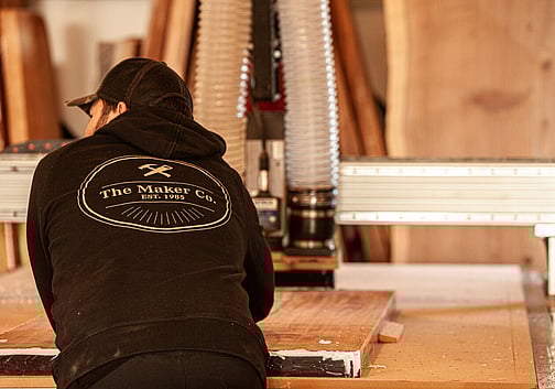 The Maker leaning on work bench