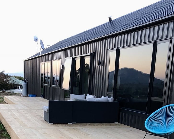 Timber decking to capture the sun from outside dark cladded home. Decking by Coull Builders, Otorohanga.
