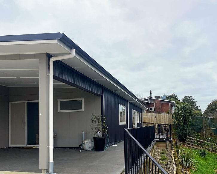 Image of fresh laid concrete at front entrance of low roof home, and new fencing.
