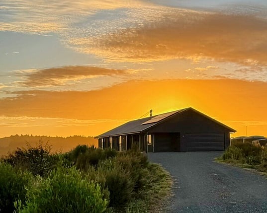 Image of dark cladded new build home with rural outlooks. Built by Coull Builders in the Waikato.