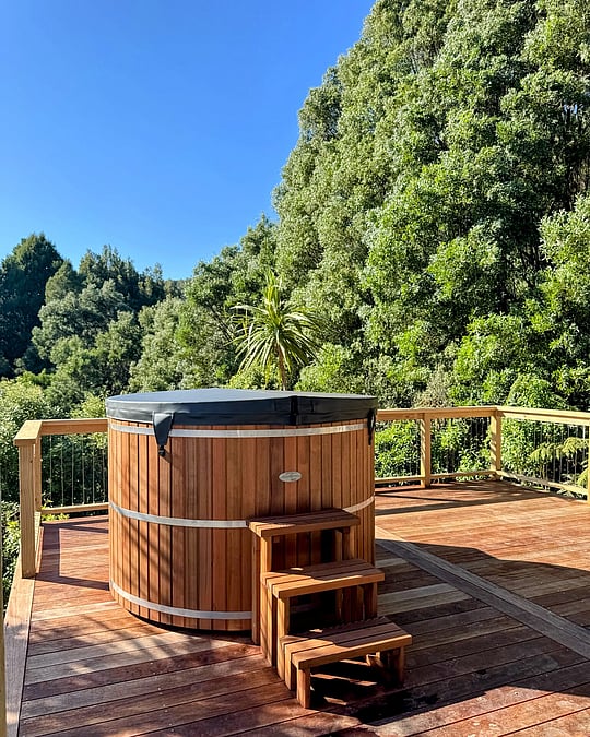 Image of spa tub on newly built decking looking out to native bush. Coull Builders, Otorohanga.