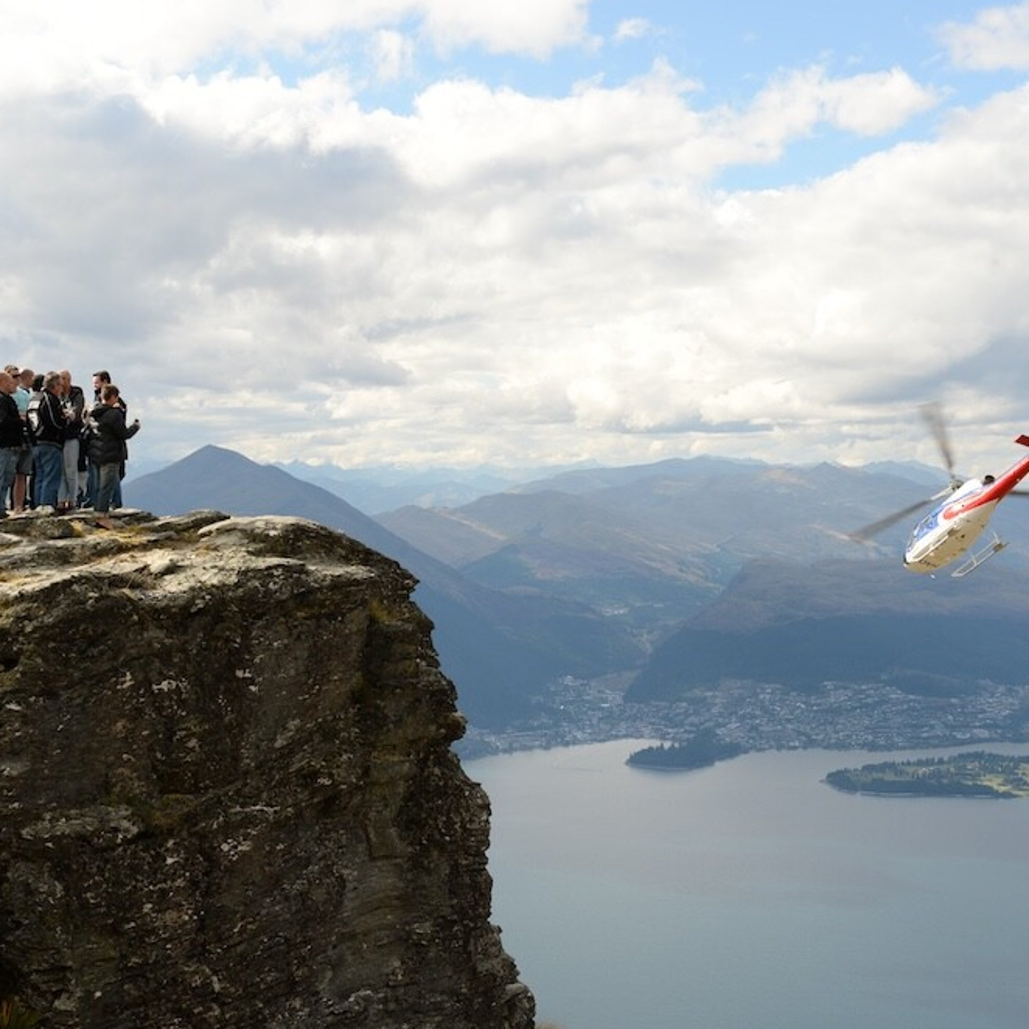 Conference attendees enjoying a helicopter trip to a ledge on a mountain in Queenstown.