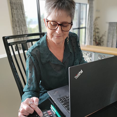 Sue Gray sitting at desk with laptop and caluculator
