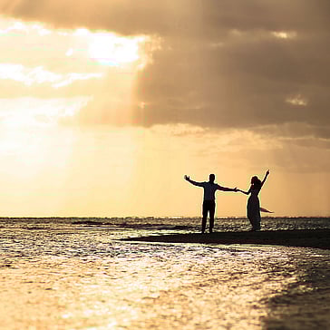 Couple enjoying a peaceful moment by the water during a destination wedding journey