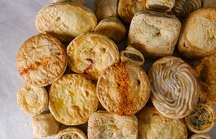 Stack of delicious pies and savouries viewed from above - made with Pieline Systems pie manufacturing equipment