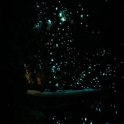 a kayak in a glow worm cave with the glow worms all lit up