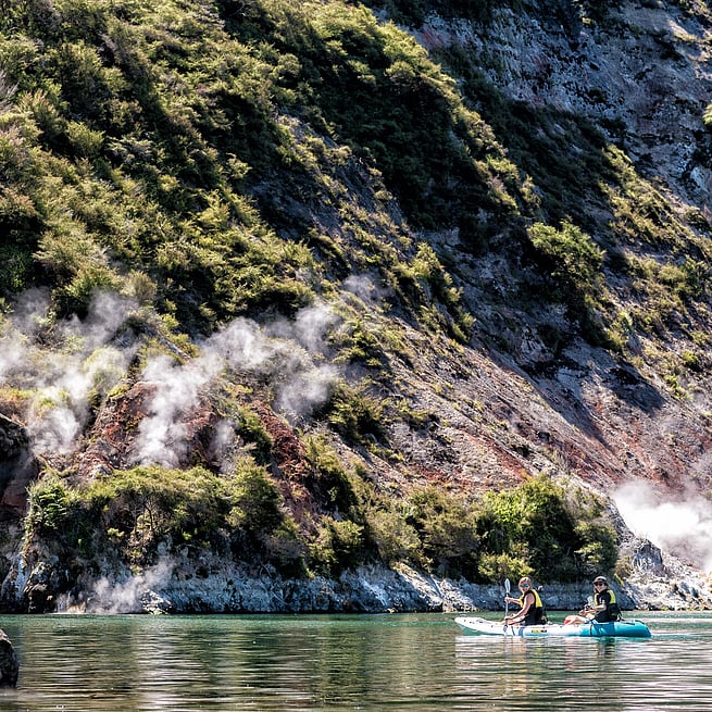 Kayakers dwarfed by the imposing Steaming Cliffs