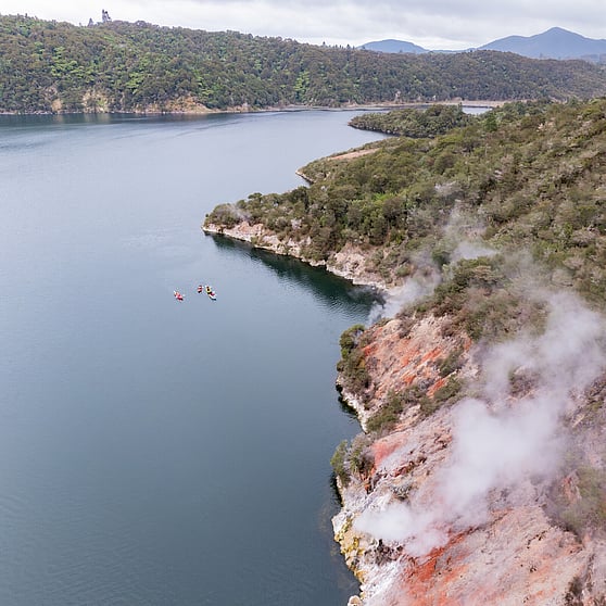 Kayaks enjoying exclusive access to paddle on Lake Rotomahana, surrounded by nature & colour landscapes