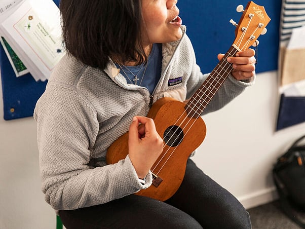 Montessori music time: teacher leads song on guitar