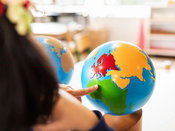 Child exploring a Montessori globe