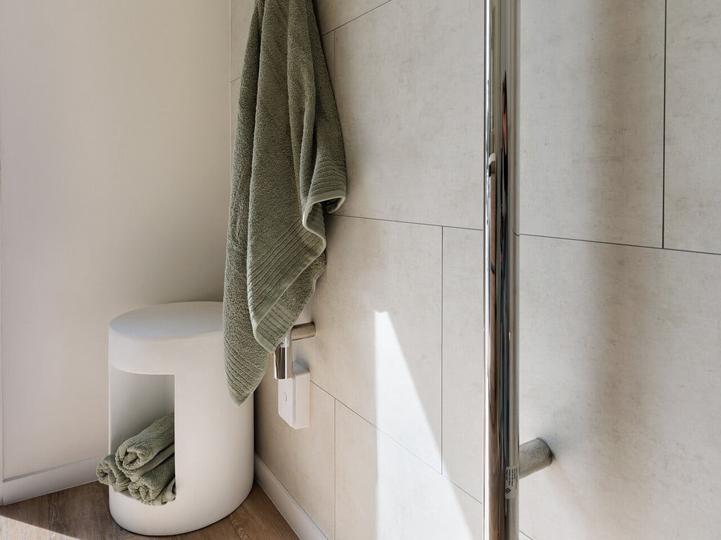 Close up of vertical towel rails with green towel.