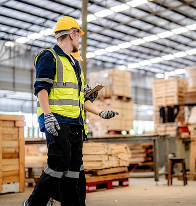 Warehouse staff in hi-vis checking inventory at a logistics site