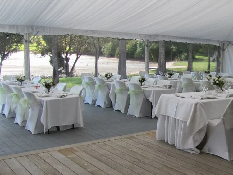 Long trestle table dining setup under fairy lights &ndash; marquee dining furniture hire Auckland