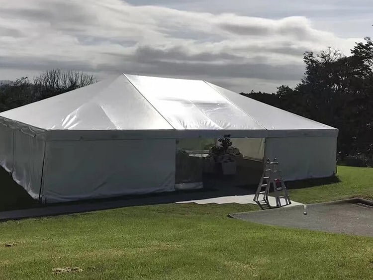 Empty white marquee on grass field &ndash; marquee only hire Auckland
