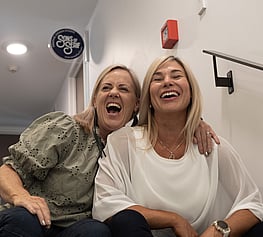 Two ladies laughing in a stairwell