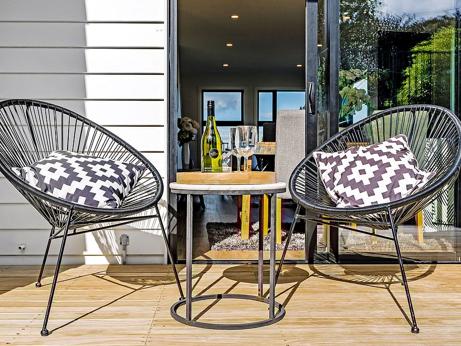 Image of two wicker chairs on the decking outside the residential new build townhouses on Roland Hill, Glen Eden, Auckland. Built by Auckland builders, Eden Construction. New Zealand.