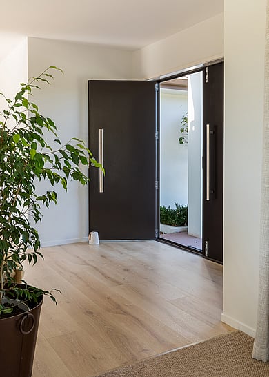 A white kitchen with natural varnished oak laminate flooring.