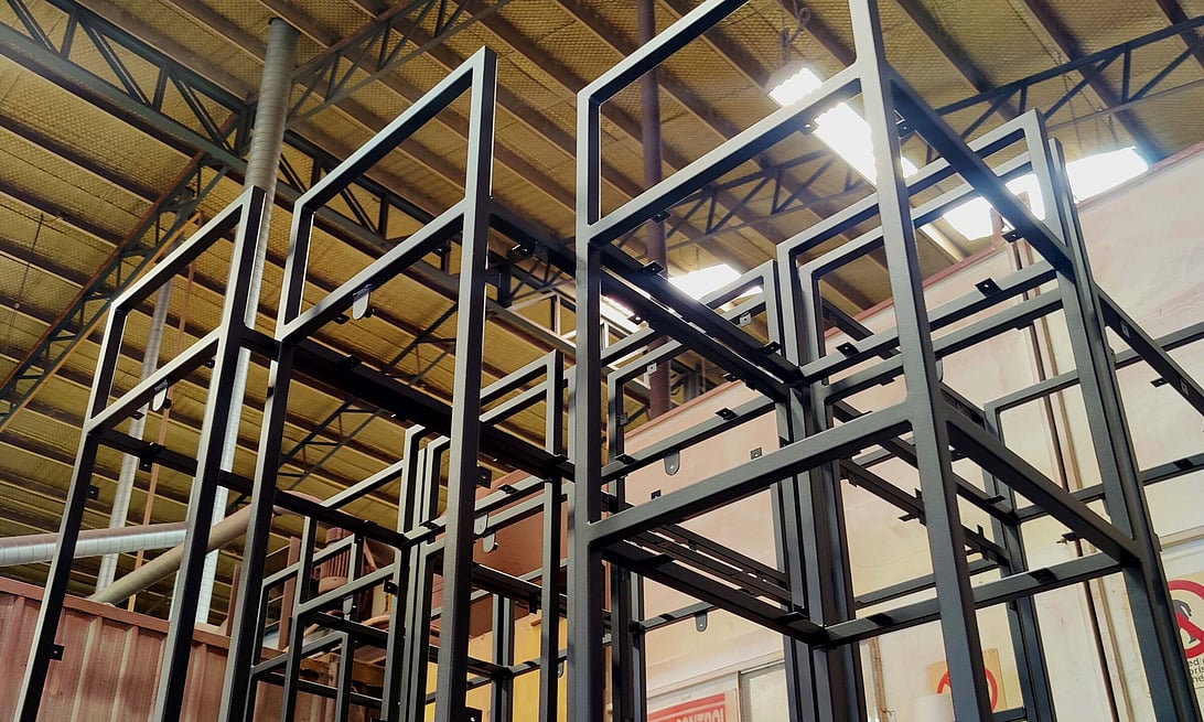 Photo of a bare shelving unit recently powder coated in gloss black at Hamilton Industrial Powder Coating