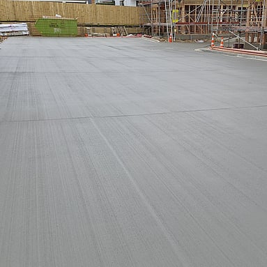 large outdoor concrete for a shared driveway area, concrete is dark and smooth with a slight brushed texture 