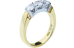 Three stone round brilliant diamond ring accented with small round brilliants - set in Platinum & 18ct yellow gold