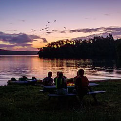 Customers enjoy a stunning sunset while waiting for darkness to fall so they can visit the glow worm caves