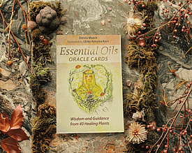 Essential Oils Oracle Cards on a moss and gem background