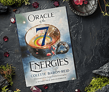 Oracle of the 7 Energies Oracle Card Deck by Colette Baron-Reid on a moss and gem background