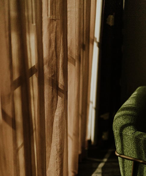 image of sheer curtain and green chair.