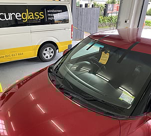 Suzuki Swift with a new windscreen, SecureGlass windscreen repair van in background