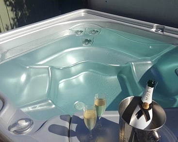 Luxurious spa pool with a champagne bottle in a cooler at Villa Rosa