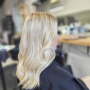 A bright blonde long wavy hair colour and style by Hair by Shiyee.