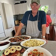 Comfort Kai image of man with plates of food on a table