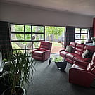 Living room of 14A Cologne Street with red leather sofa and lazy boy chairs