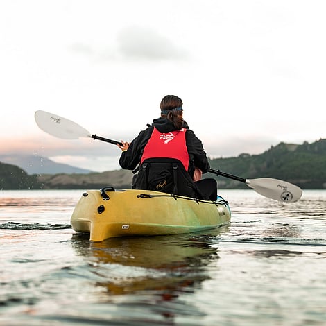 Customer kayaking on gentle waters heading out to the hidden glow worm caves along the lakes edge