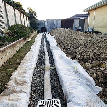 Open drainage system, white sheet, gravel and long pipe laid down by Simon.