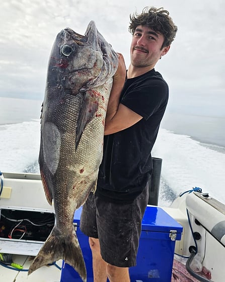 Blake holding fish out on the boat