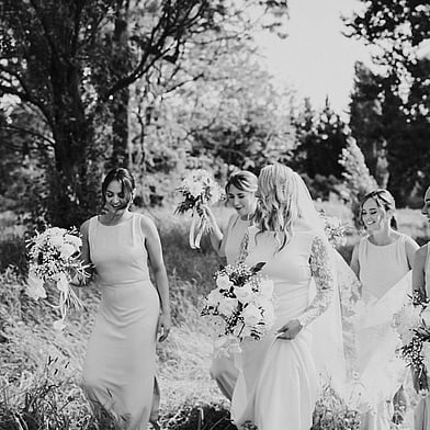 Wedding Planning and Styling by The Event Girl - bride and her bridesmaids walking through a field