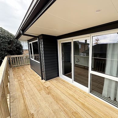 Image of a moody dark blue cladded small building with decking wrapped around it on Vercoe Road. Built by Ardent Building Developments, Hamilton. Waikato, New Zealand.
