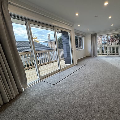 Image of fresh new neutral toned and carpeted lounge and dining area. Vercoe Road small building. Built by Ardent Building Developments, Hamilton. Waikato, New Zealand.