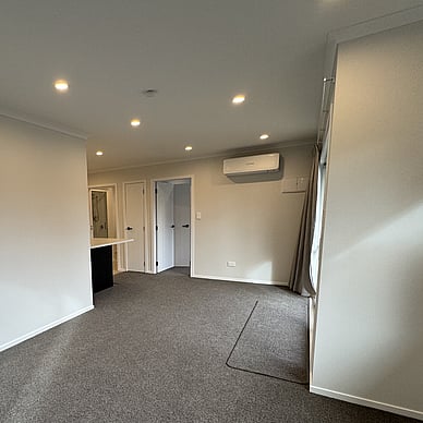 Image of fresh new neutral toned and carpeted lounge and dining area. Vercoe Road small building. Built by Ardent Building Developments, Hamilton. Waikato, New Zealand.