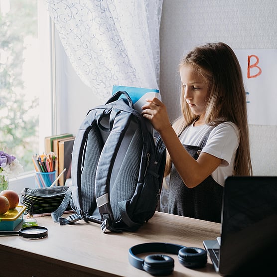 before school programme, girl getting her bag ready