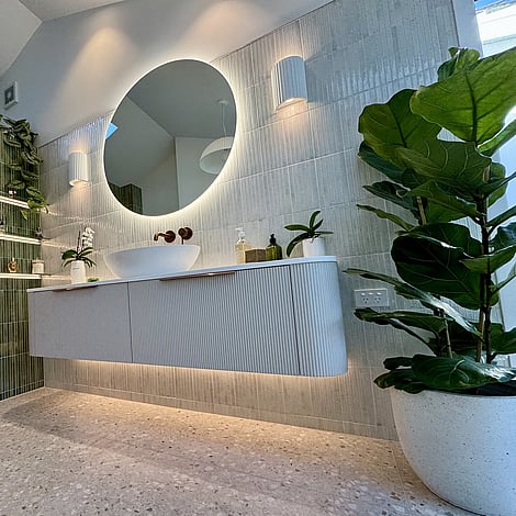 Image of curved finger tiled cabinet in soft grey, with white basin and circle mirror in this Bedford Road bathroom extension. Built by Ardent Building Developments, Hamilton. Waikato, New Zealand.