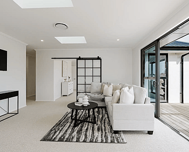 Image of natural light filled lounge with modern large white comfy lounges suite in Collinson Street, Pirongia new home, by Waikato residential builders Whitechurch Construction Limited.