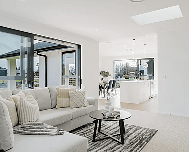 Image of natural light filled lounge with modern large white comfy lounges suite in Collinson Street, Pirongia new home, by Waikato residential builders Whitechurch Construction Limited.