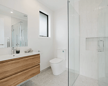 Image of modern neutral ensuite with timber cabinetry and pale grey tiling in Collinson Street, Pirongia new home, by Waikato residential builders Whitechurch Construction Limited.