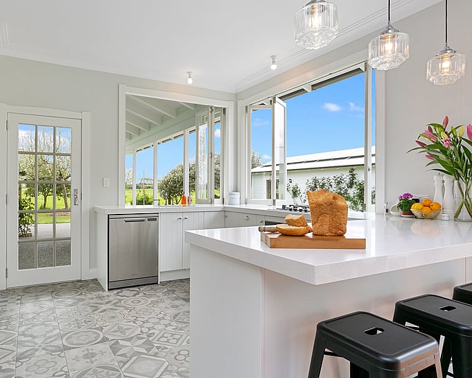 Image of fresh white kitchen with vintage tiled flooring on Oakshott Road, renovated by Whitechurch Construction, Waikato residential builders.