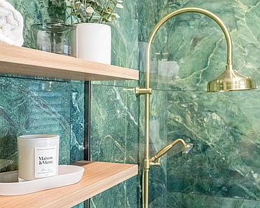 Close up image of brass shower head in green marble tiled shower in renovated heritage bathroom. Renovated by local Te Awamutu residential builders, Whitechurch Construction.