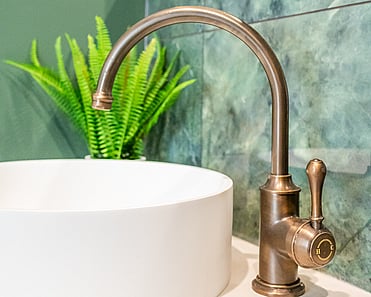 Close up image of copper tap in newly deep sage & white renovated heritage bathroom. Renovated by local Te Awamutu residential builders, Whitechurch Construction.